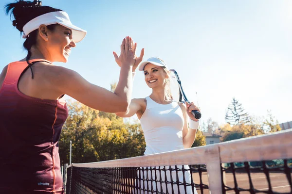 A nők pacsiznak egy jó teniszmeccs után. — Stock Fotó