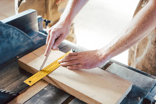 Primo piano a portata di mano del falegname che segna un taglio con la matita — Foto Stock