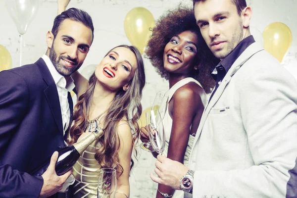 Gente festaiola in un club che festeggia e versa champagne — Foto Stock