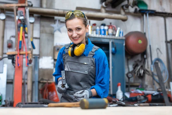 Žena dělnice značící obrobek ve své dílně — Stock fotografie