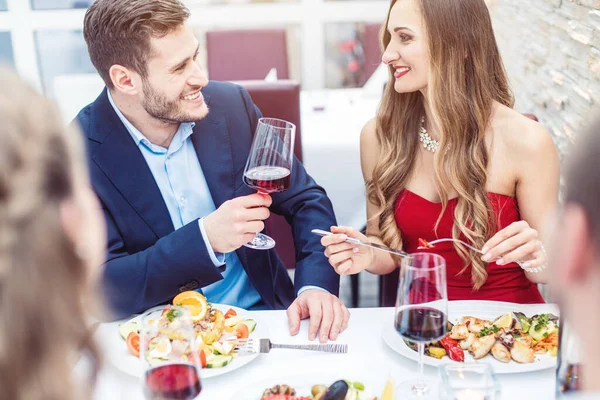 Люди в итальянском ресторане пьют вино и едят макароны — стоковое фото