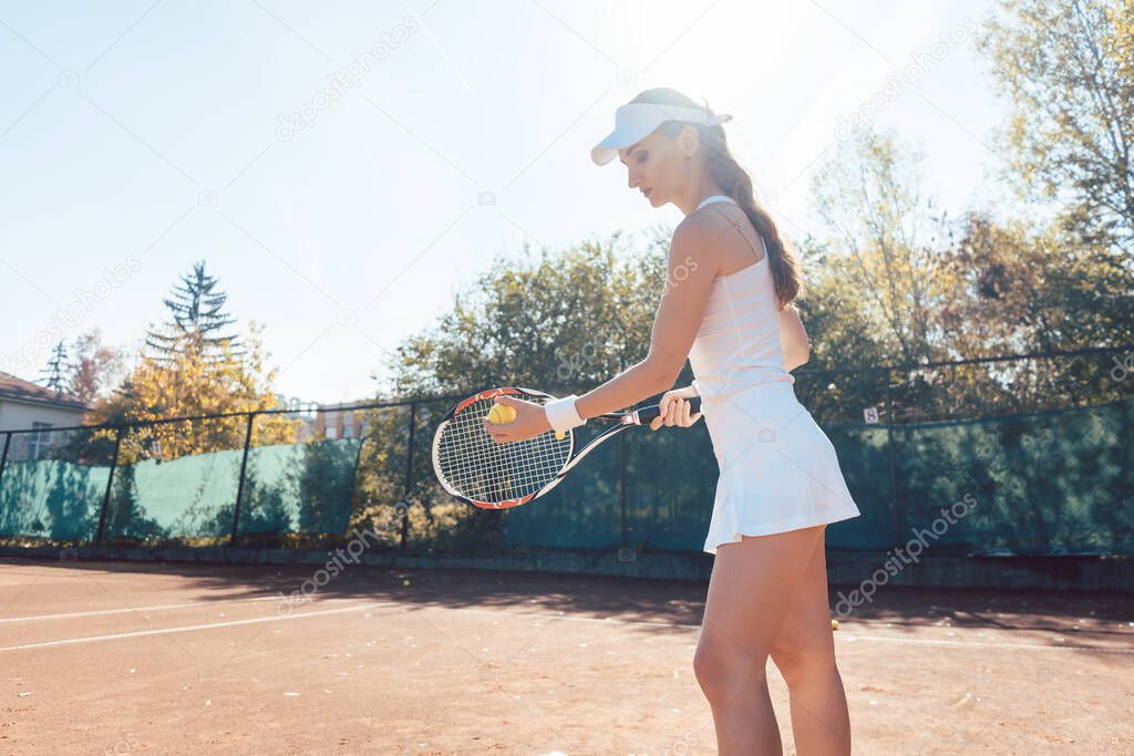 Woman serving the ball in tennis match