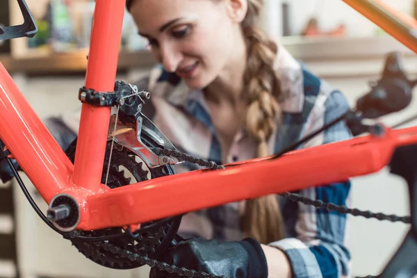 Fietstechnicus in haar werkplaats werkt op de fiets — Stockfoto