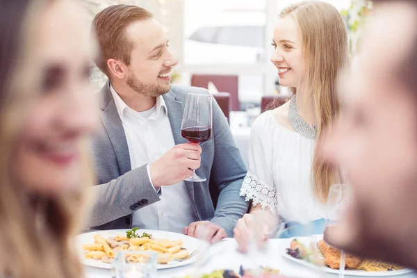 Gente alegre disfrutando de bebidas y comida en el restaurante italiano —  Fotos de Stock