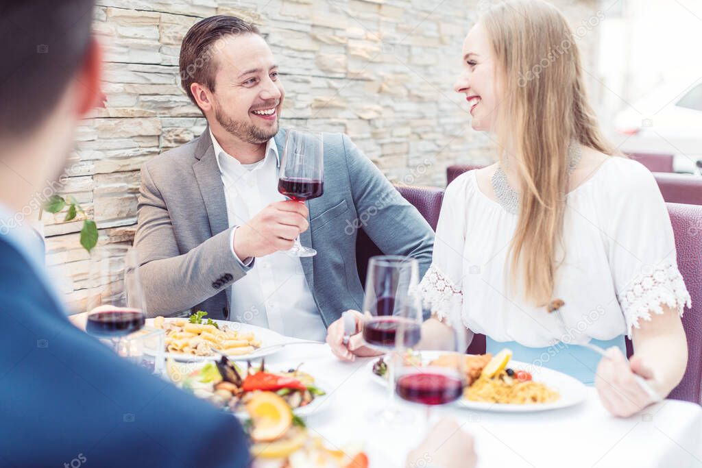 People in an Italian restaurant drinking wine and eating pasta