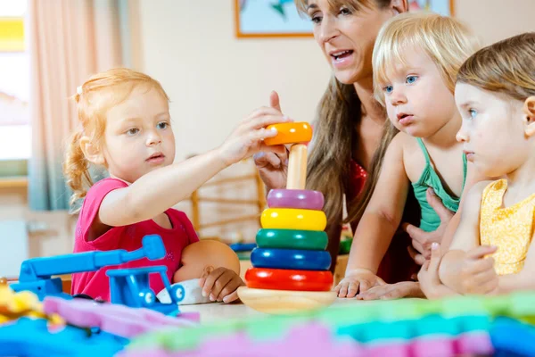 Niños en guardería aprendiendo y jugando —  Fotos de Stock