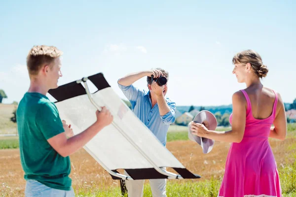 Fotografo, modella e assistente sul set durante un servizio fotografico — Foto Stock