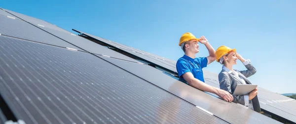 Travailleur et gestionnaire de ferme solaire regardant vers le soleil — Photo