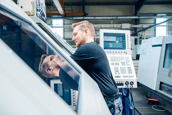 Worker resetting a cnc lathe machine in manufacturing factory — Stok fotoğraf