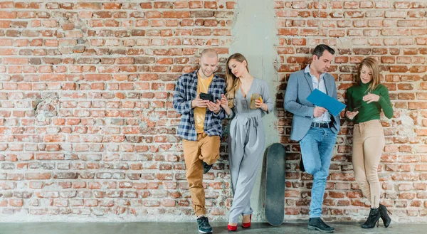 Team of people in startup company standing on brick wall — Stockfoto