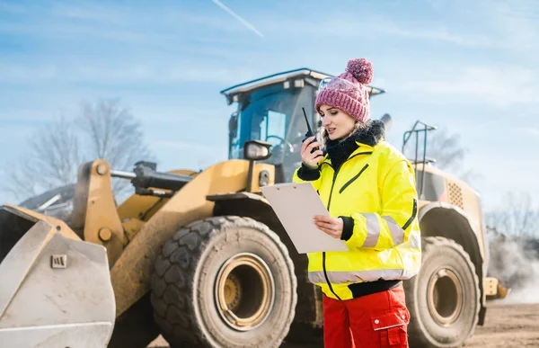 Mulher com walkie talky em instalação de compostagem despachando entregas — Fotografia de Stock