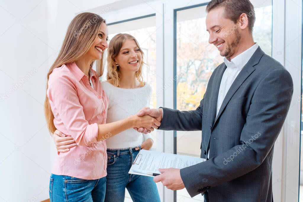 Real estate broker shaking hands with tenants