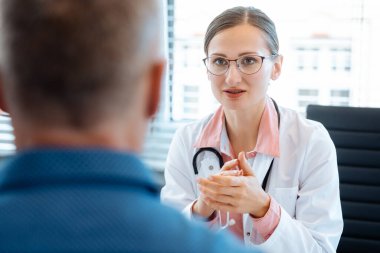 Ofisinde erkek hasta ile güzel doktor