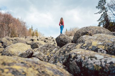 Taştan bir nehirde yürüyüş yapan kadın