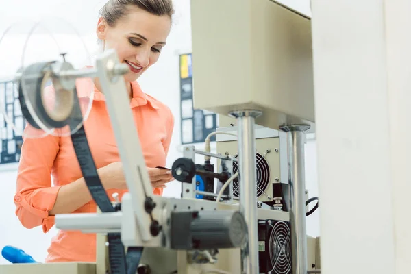 Operário que verifica o rótulo têxtil fresco da máquina de impressão — Fotografia de Stock