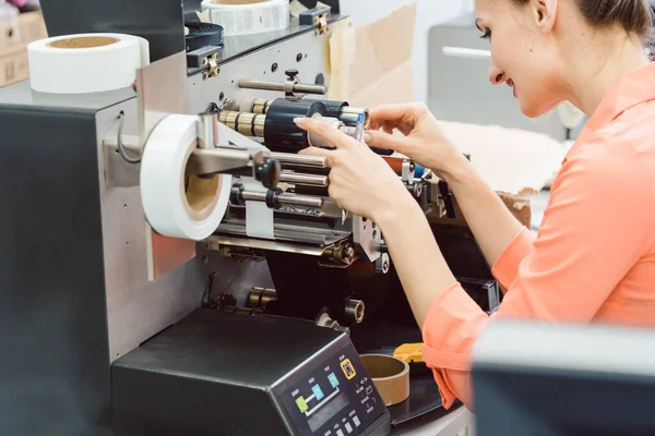 Woman working on label printing machine