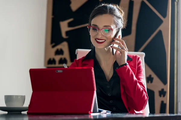 Üzletasszony dolgozik a számítógépével, miközben telefonál — Stock Fotó