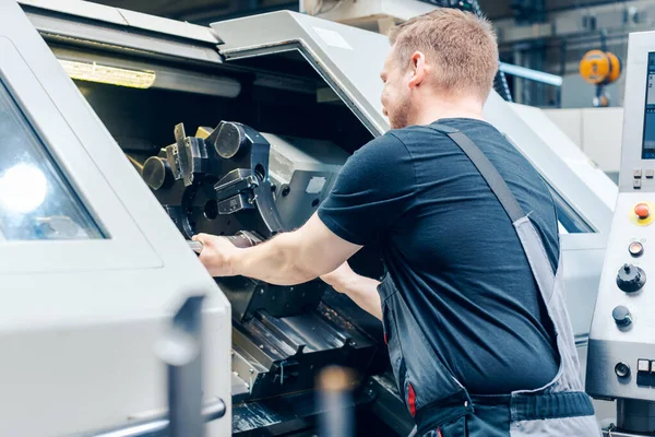 Trabajador experimentado que cambia la configuración de la herramienta de la máquina de torno — Foto de Stock