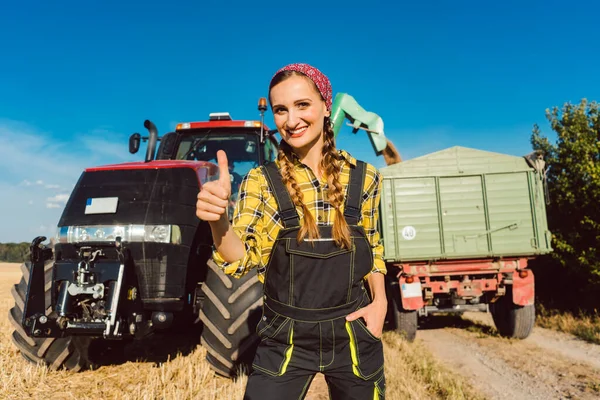 Tarım makinelerinin önünde çiftçi kadın thumbs-up veren — Stok fotoğraf