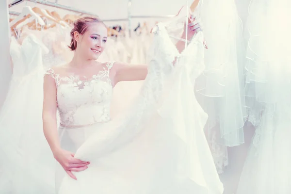 Молодая женщина делает покупки в свадебном магазине для платья носить — стоковое фото