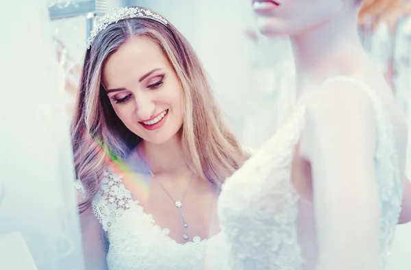 Bride to be admiring the dress on mannequin in the wedding shop — Stock Photo, Image