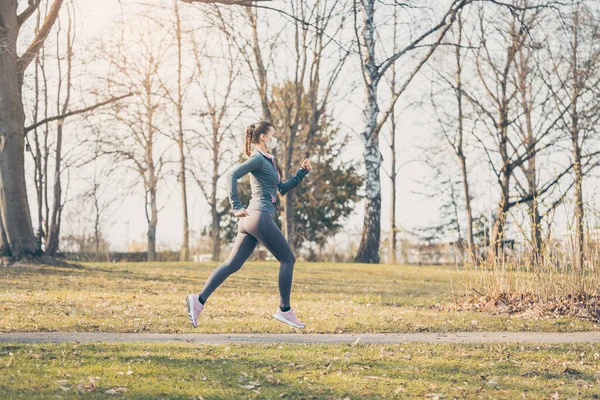 Mulher apta a correr durante crise de saúde com máscara facial — Fotografia de Stock