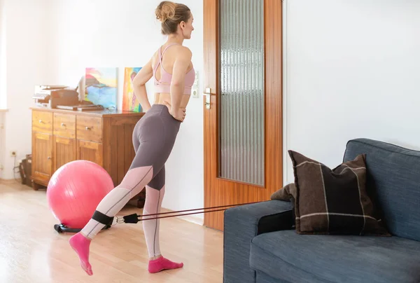 Beautiful woman staying fit during quarantine doing fitness exercise at home — Stock Photo, Image