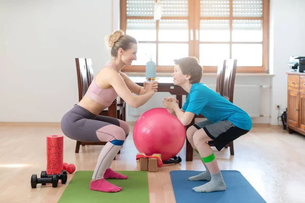 Family doing squats on floor at home during Covid-19 curfew — Stock Photo, Image