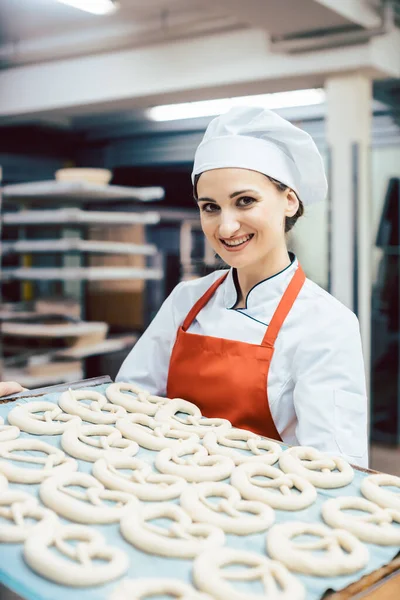 Panettiere che mostra foglio con pane pronto per essere cotto — Foto Stock