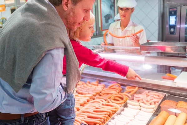 Familjeshopping efter färskt kött i en stormarknad — Stockfoto