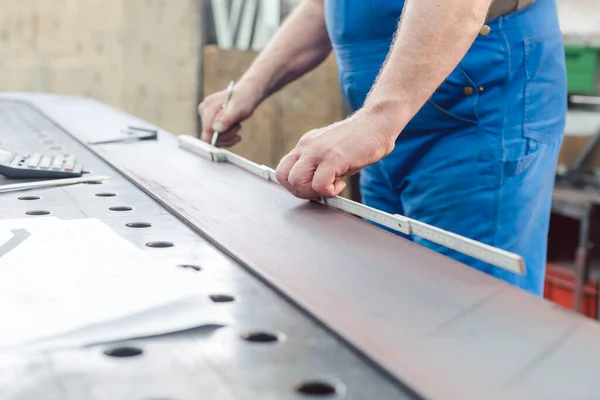 Metalworker using folding rule to measure steel strip — Stock Photo, Image