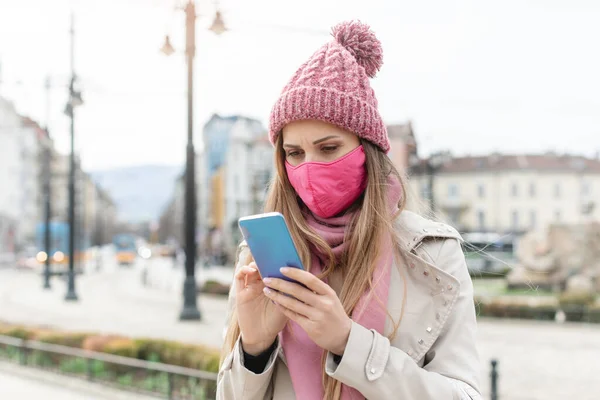 Angst vrouw dragen corona masker controleren van nieuws op haar telefoon — Stockfoto