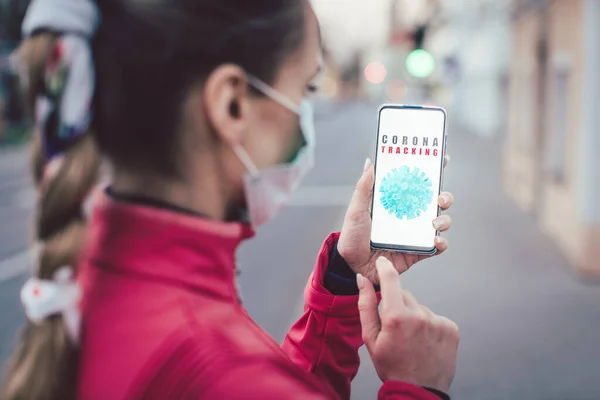 Женщина, использующая телефон с установленным приложением слежения за коронавирусом — стоковое фото