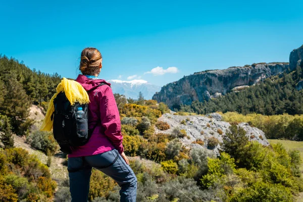 Donna che si riposa dalle escursioni guardando le colline e la natura in primavera — Foto Stock