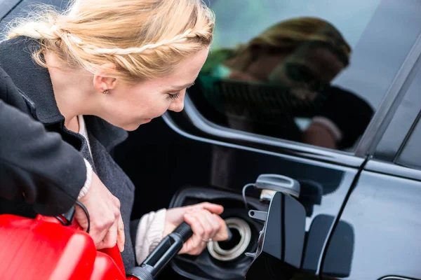 Wanita mengisi mobil dengan gas dari tabung cadangan — Stok Foto