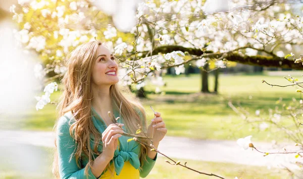 Mooie vrouw genieten van de lente bloesem in een park — Stockfoto