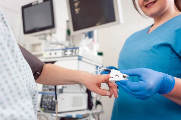 Enfermera preparando sensor de presión arterial para cirugía al paciente — Foto de Stock