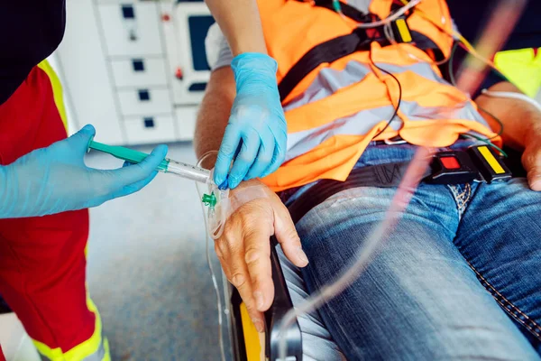 Emergency doctor administering injection needle in ambulance — Stock Photo, Image