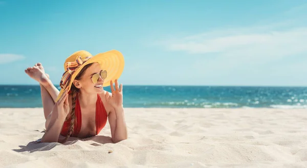 Женщина наслаждается отдыхом на берегу моря, загорает на песке — стоковое фото