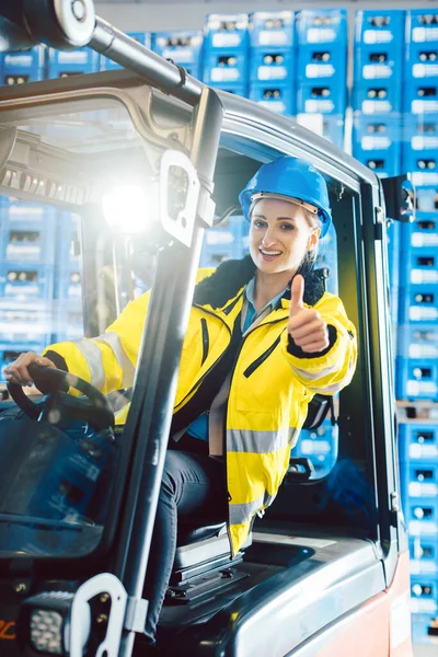 Mujer trabajadora mostrando pulgares hacia arriba en el centro de entrega logística —  Fotos de Stock
