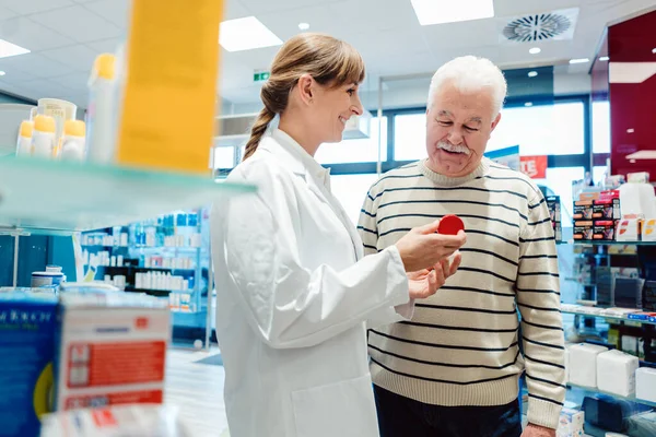 Uomo anziano con farmacista in farmacia — Foto Stock