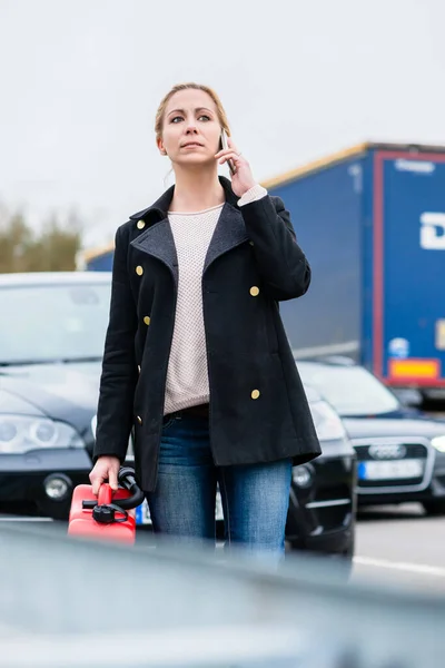 Woman out of gas with her car phoning for somebody to pick her up — Stock Photo, Image