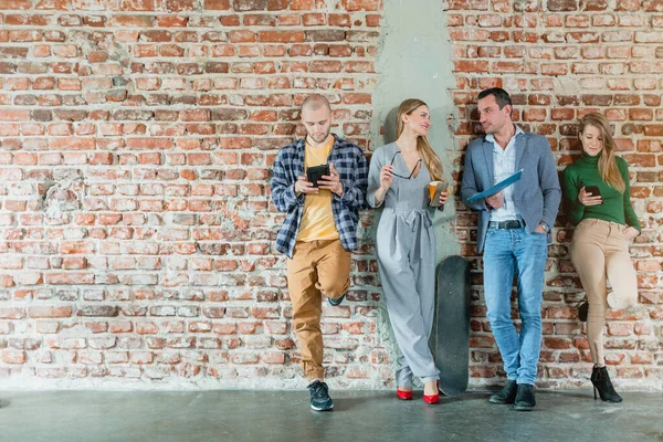 Team of people in startup company standing on brick wall — Stockfoto