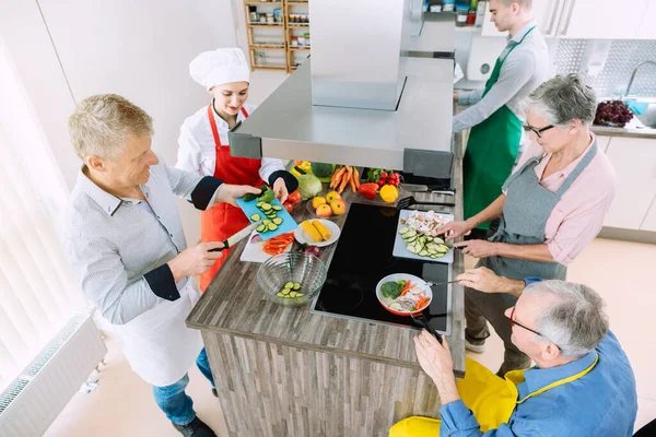 Aprender a cocinar en grupo en la cocina de entrenamiento con nutricionista — Foto de Stock