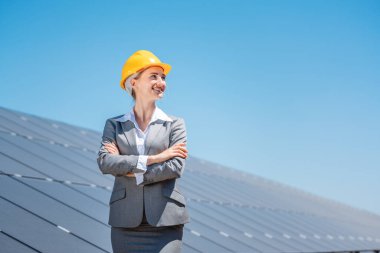 Güneş panellerinin önünde duran temiz enerjiye kadın yatırımcı