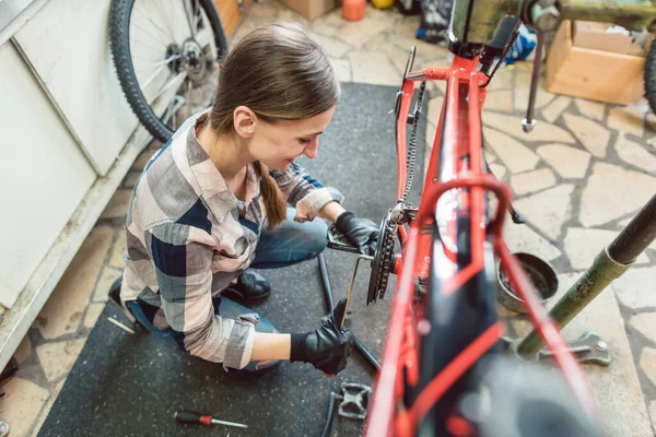 Fietstechnicus in haar werkplaats werkt op de fiets — Stockfoto