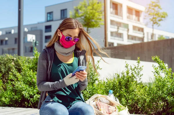 顔のマスクをした女性が鍵を開けると外に座って — ストック写真