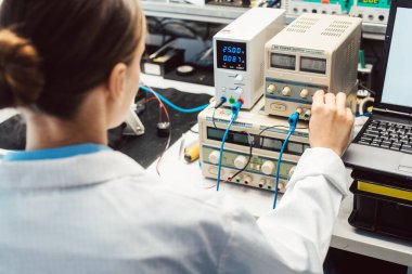 Elektronik laboratuarındaki mühendis kadın EMC uyumunu test ediyor.
