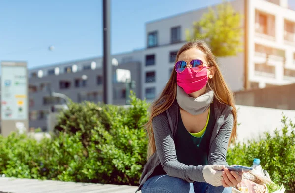 Femme avec masque facial assis à l'extérieur comme verrouillage s'ouvre — Photo