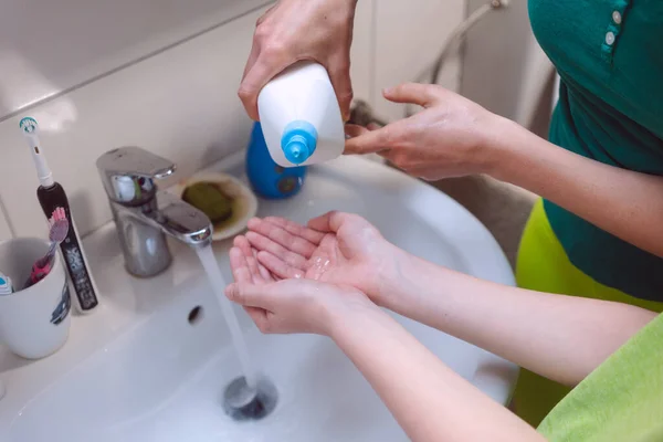 Mother disinfecting her sons hands — Stock Photo, Image